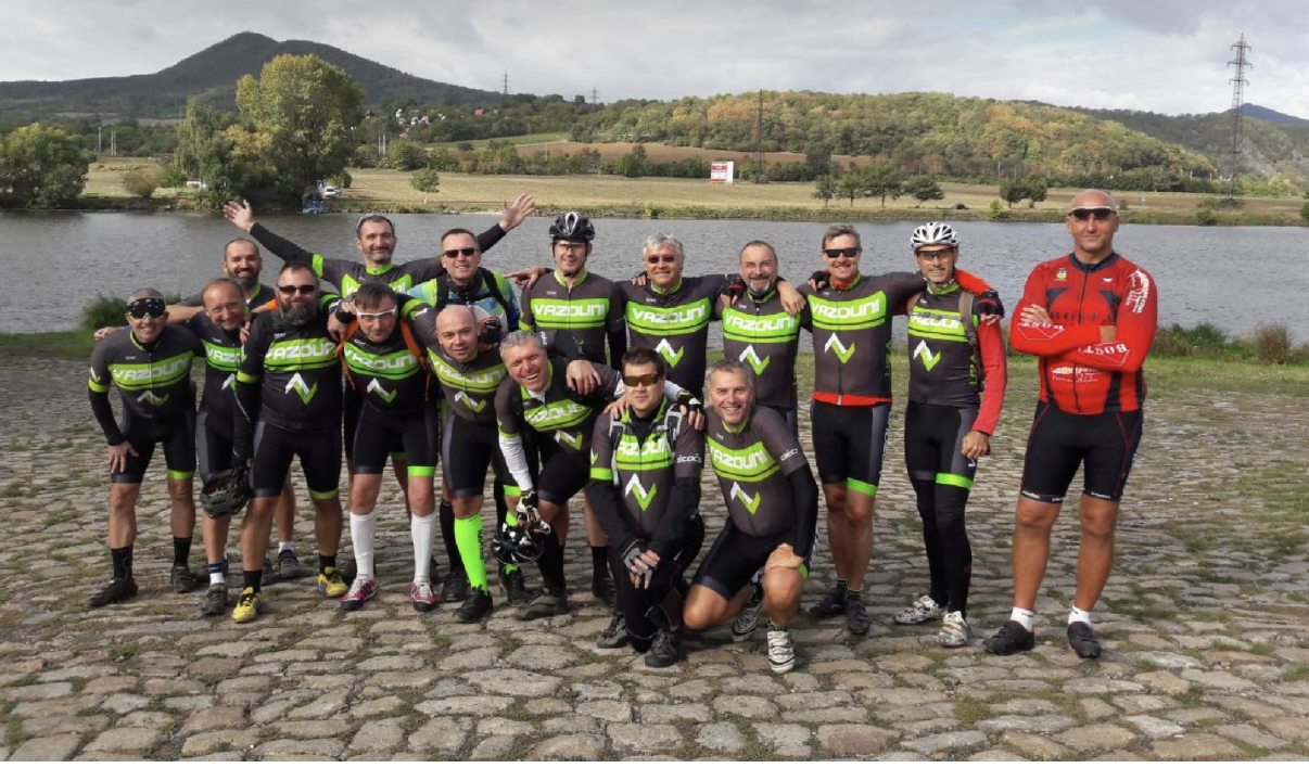 Skupinová fotografie Vazounů v cyklistických dresech u vody